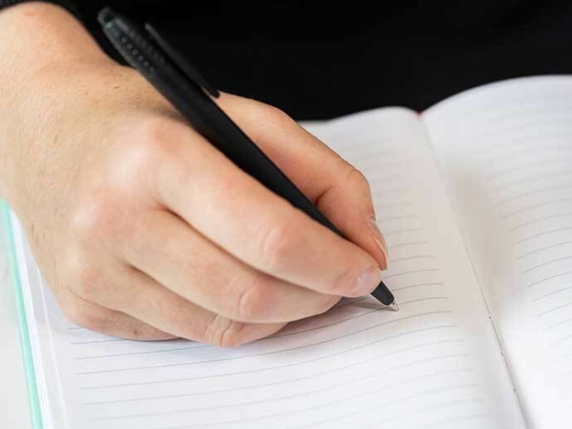 Skriver affärsplan i anteckningsblock.