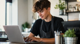 Ung man sommarjobbar vid kafébordet